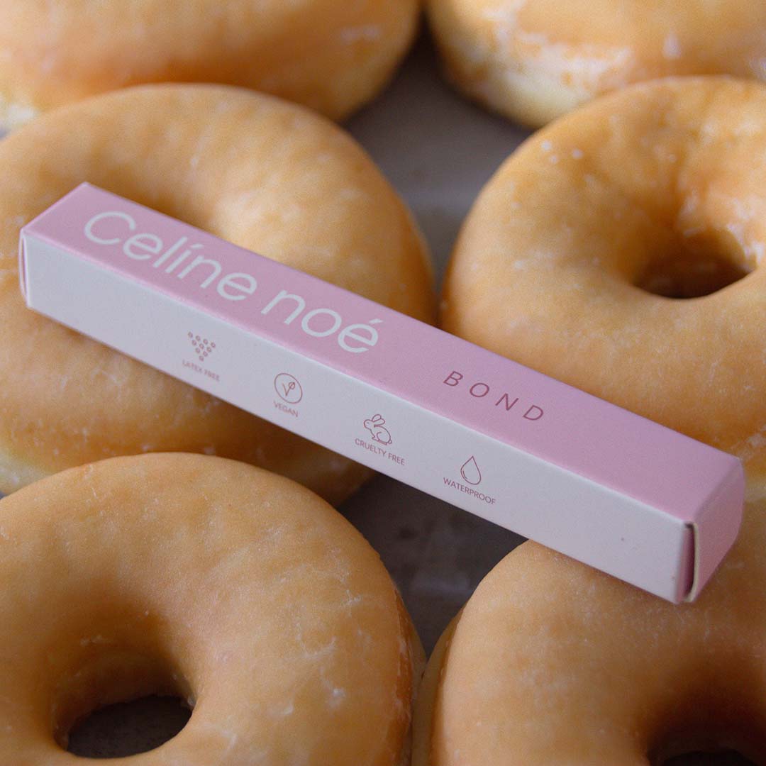 Bond verpakking voor diy lashes neergelegd op suiker donuts