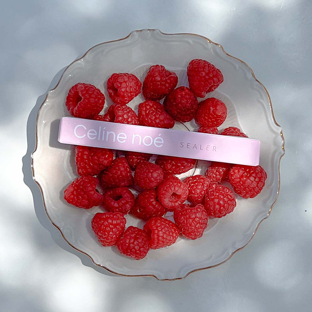 Sealer voor lash sfeerbeeld neergelegd op frambozen op een schaaltje in de zon