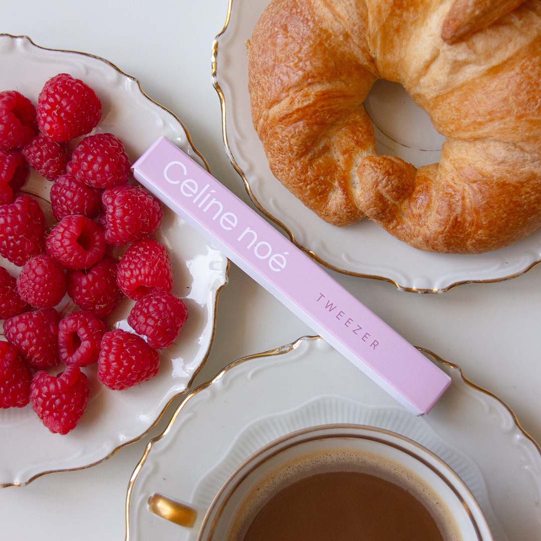 Tweezer van Celíne noé tussen een ontbijt met koffie een croissant en frambozen op schaaltjes