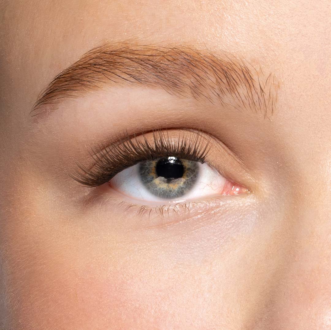 Close up macro shot van Bronze me nepwimpers een donkerbruine tint lashes op een oog in 12mm van Celine noé.